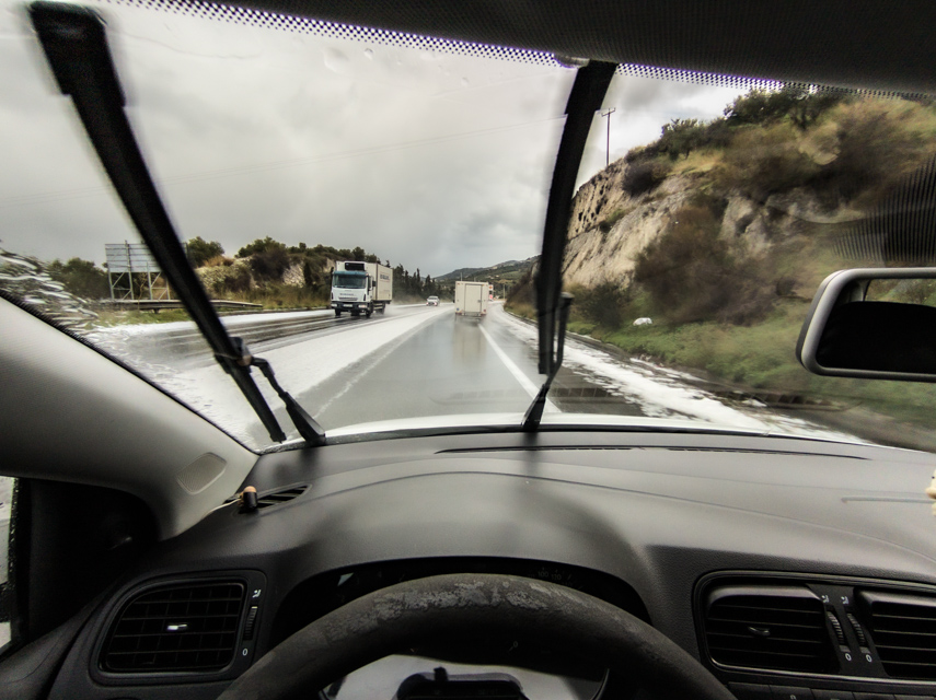 Wet road through moving windscreen wipers