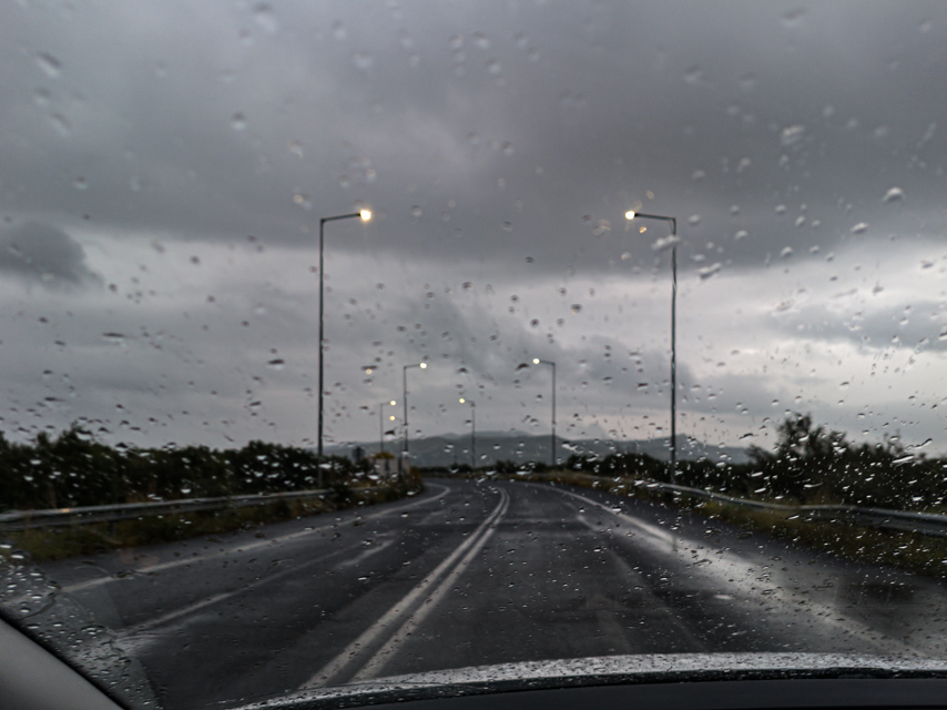 Rain falling across a dark road