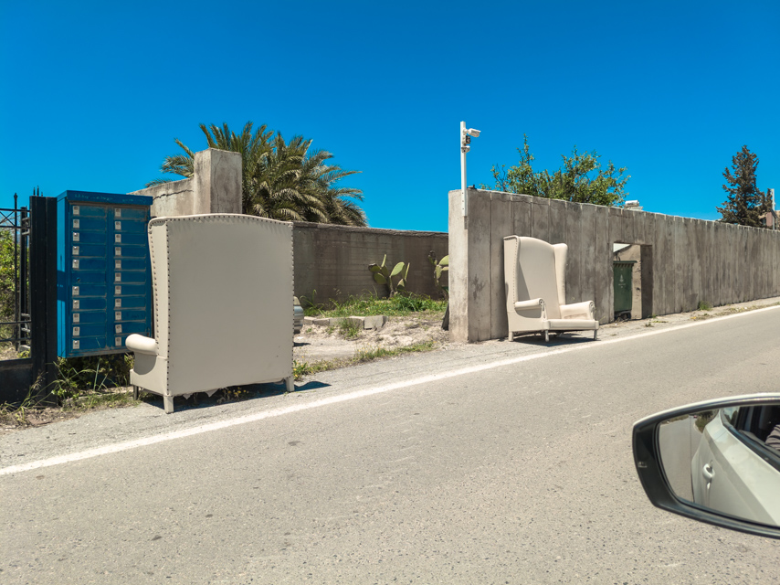 Two empty chairs beside a rural road